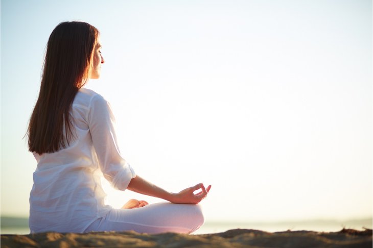 Woman meditating with arms raised